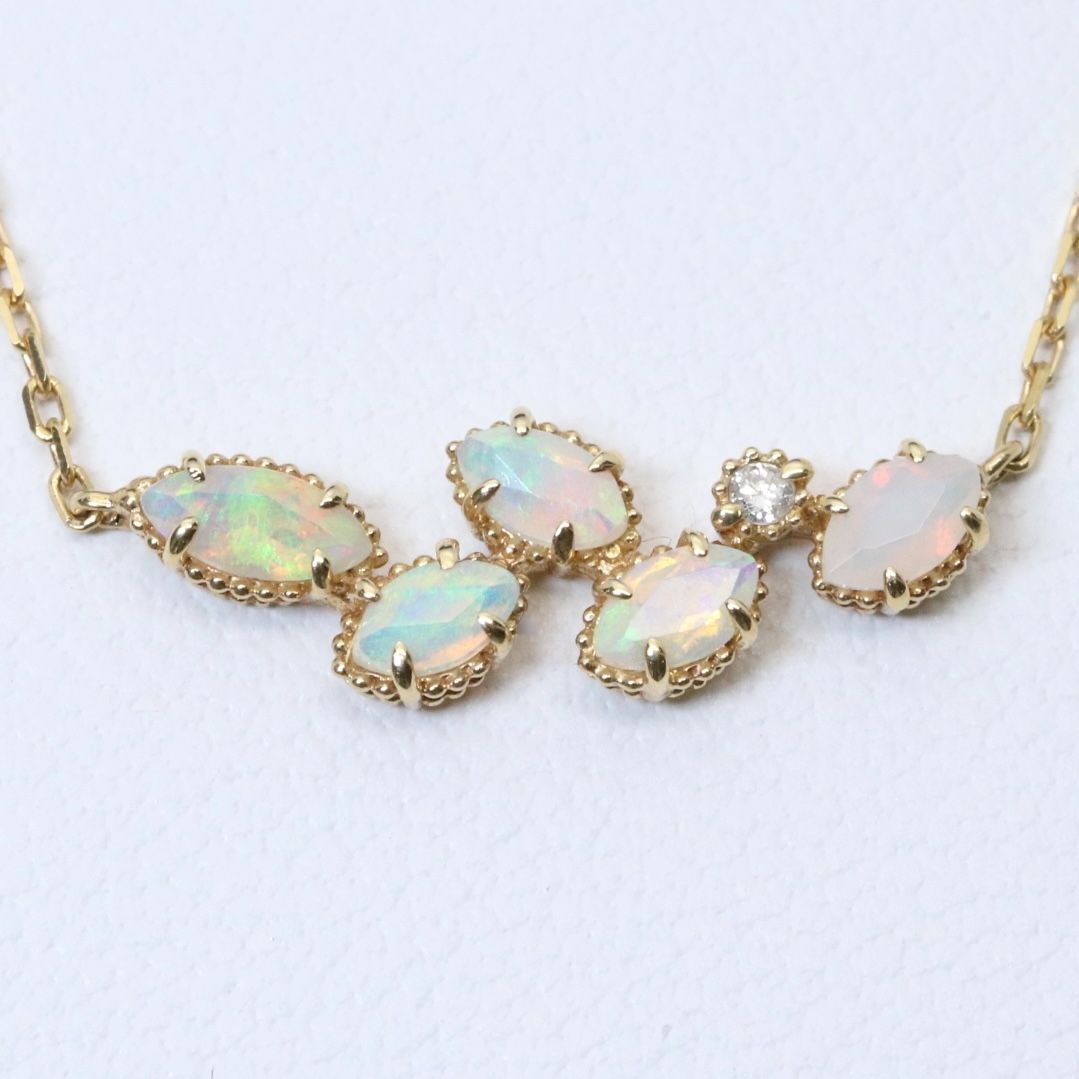 Valuable discontinued agate opal necklace with K18 and K14 gold and diamond accents on 5mm grid background