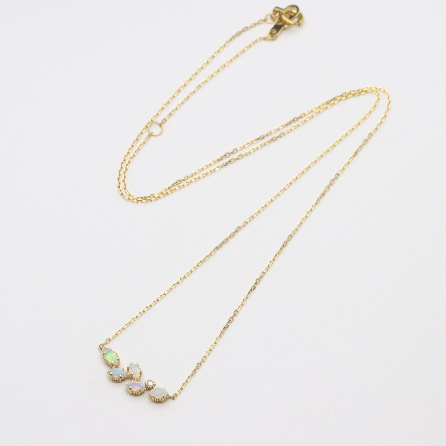 Valuable discontinued agate opal necklace with K18 and K14 gold and diamond accents on 5mm grid background