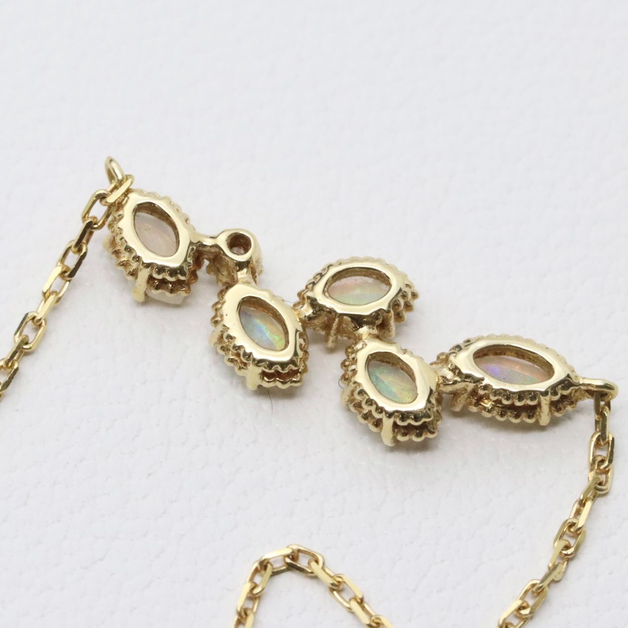 Valuable discontinued agate opal necklace with K18 and K14 gold and diamond accents on 5mm grid background