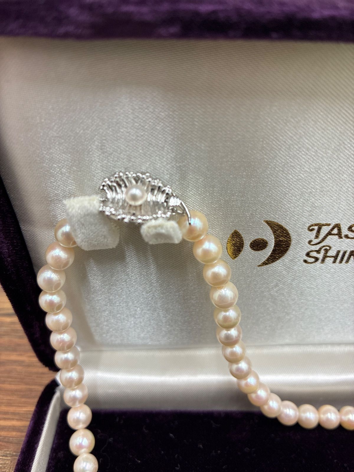 Used TASAKI pearl necklace with imprint displayed alongside its case