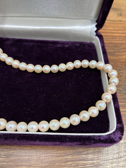 Used TASAKI pearl necklace with imprint displayed alongside its case