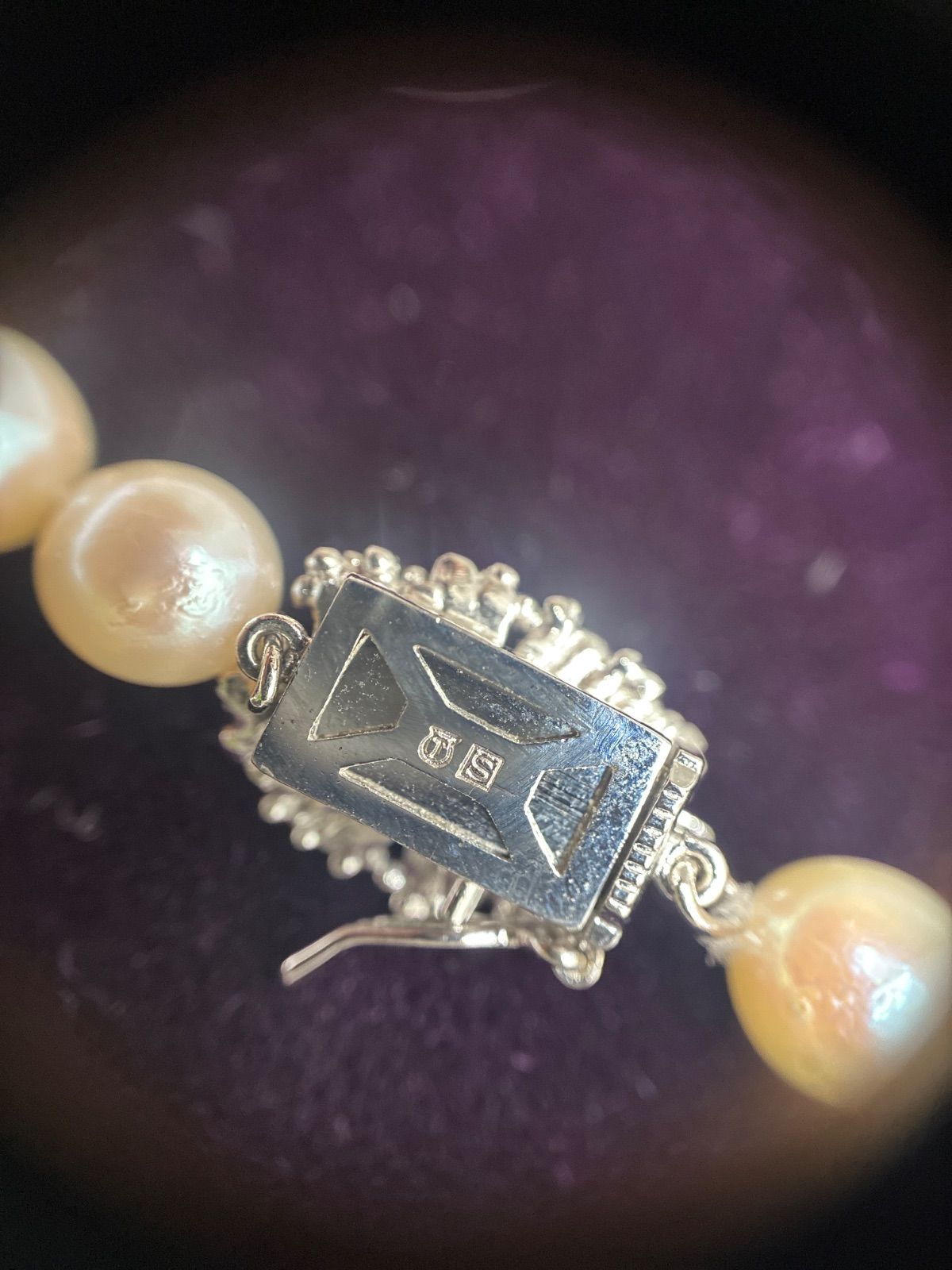 Used TASAKI pearl necklace with imprint displayed alongside its case