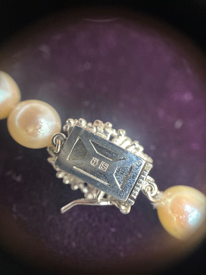Used TASAKI pearl necklace with imprint displayed alongside its case