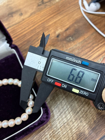 Used TASAKI pearl necklace with imprint displayed alongside its case