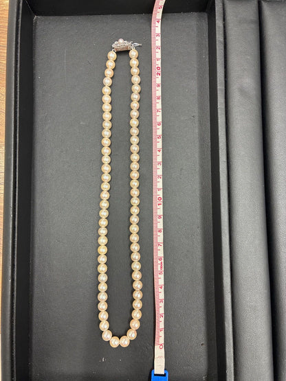 Used TASAKI pearl necklace with imprint displayed alongside its case