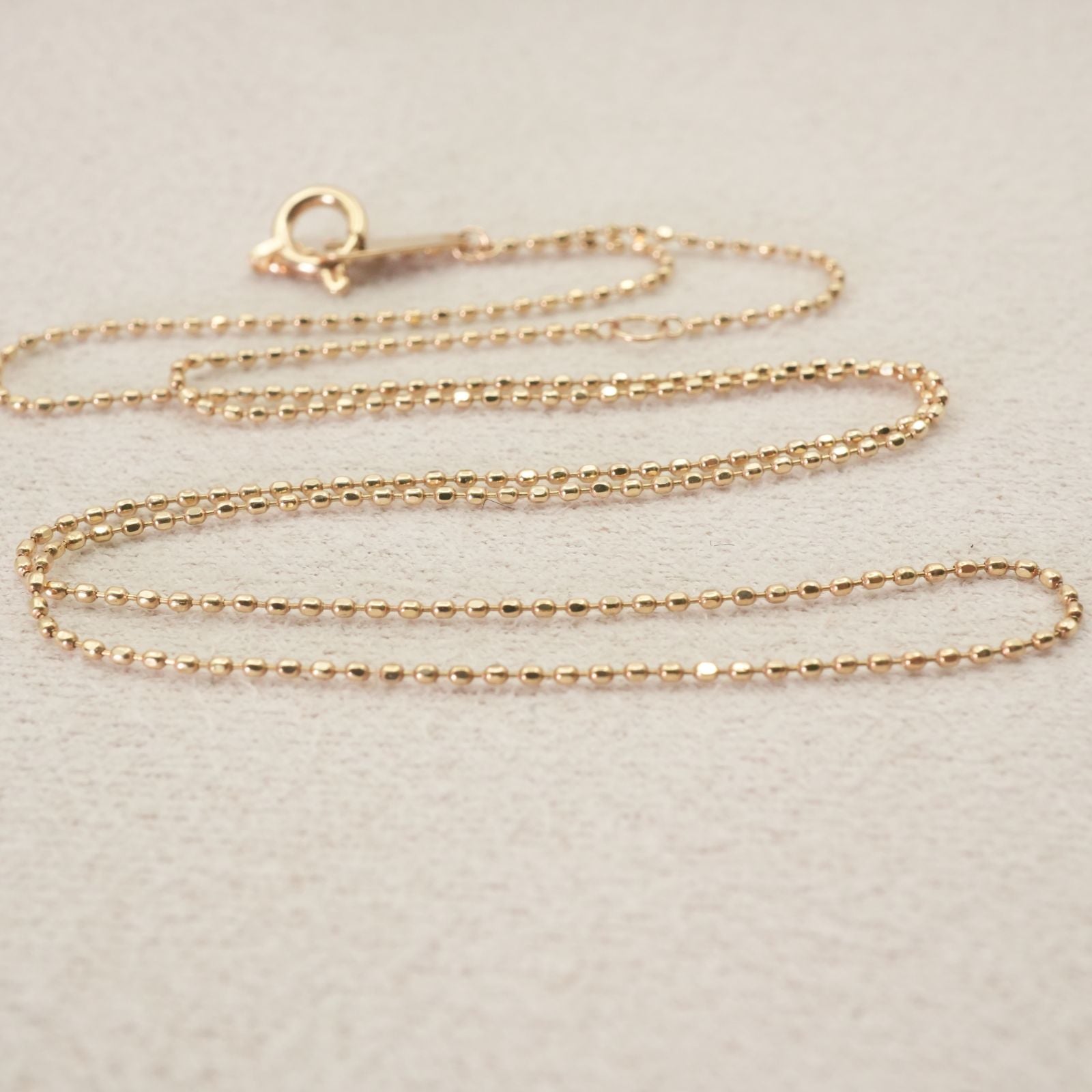 Close-up of Agat Ball Chain Necklace in K10 gold with polished beads and clasp