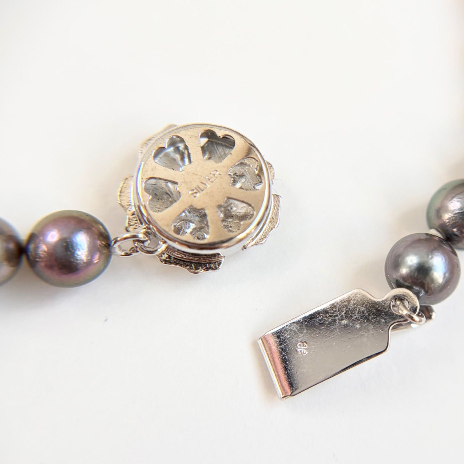 Silver necklace featuring a round black Akoya pearl 6.5-7mm with attached identification card on a 42cm chain