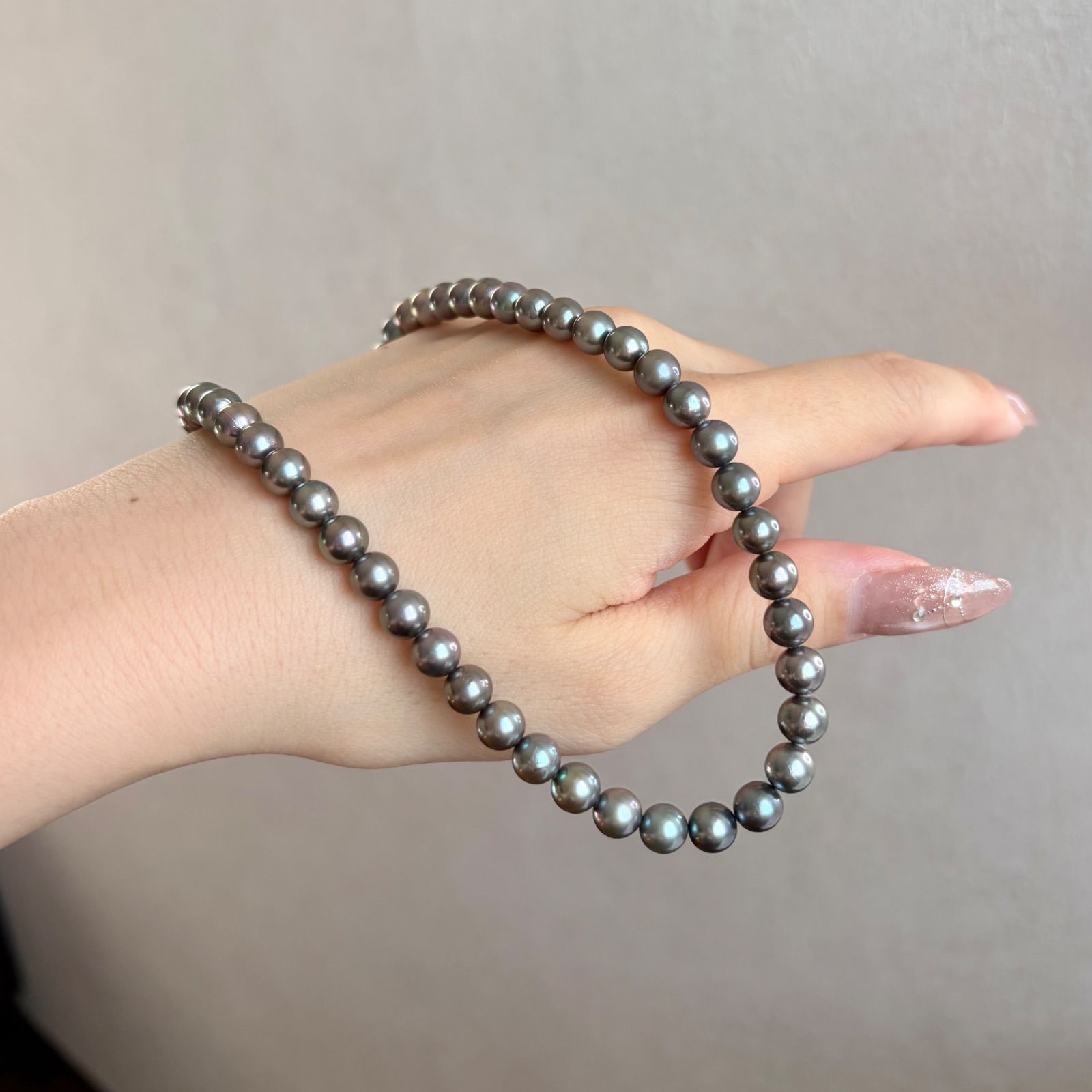 Silver necklace featuring a round black Akoya pearl 6.5-7mm with attached identification card on a 42cm chain