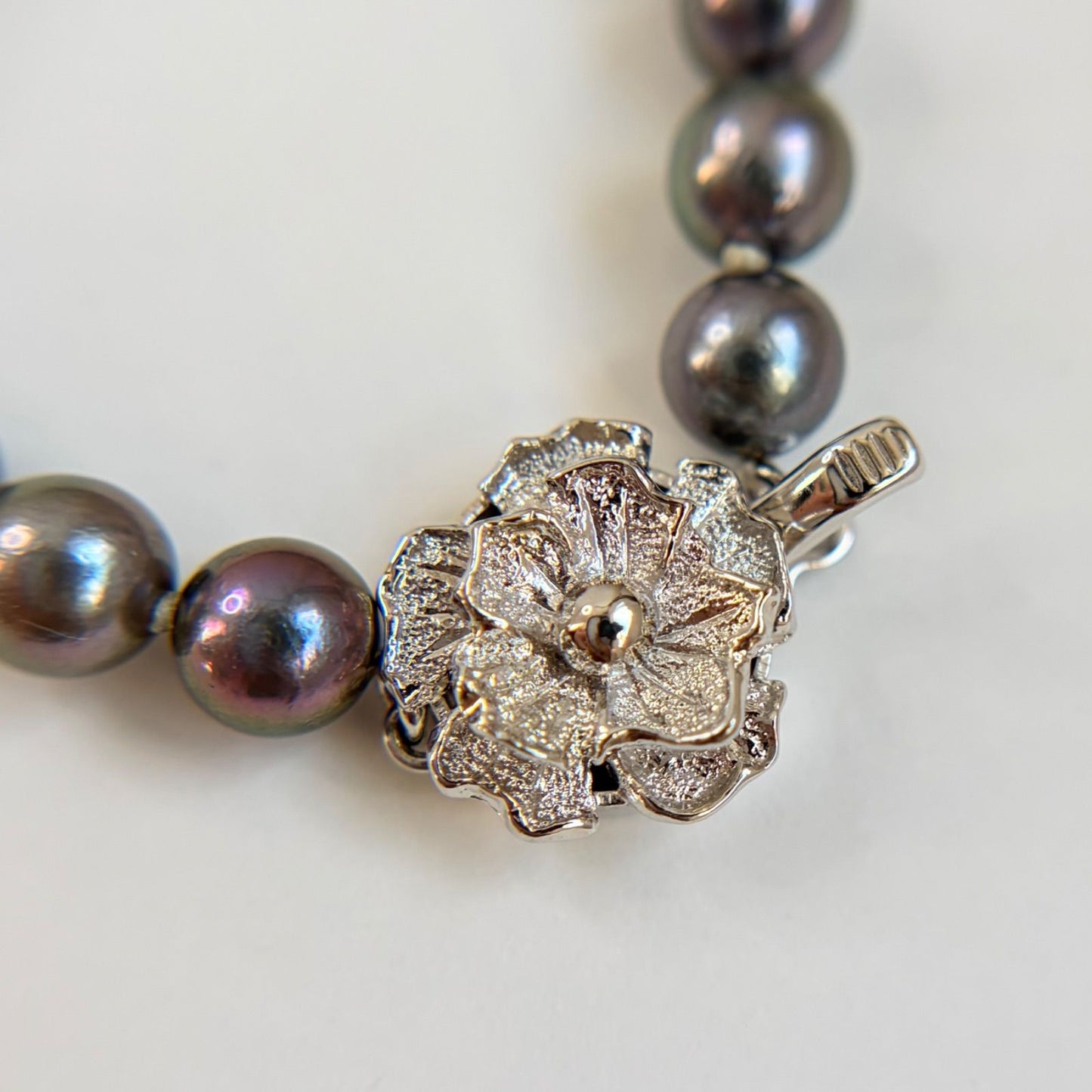 Silver necklace featuring a round black Akoya pearl 6.5-7mm with attached identification card on a 42cm chain