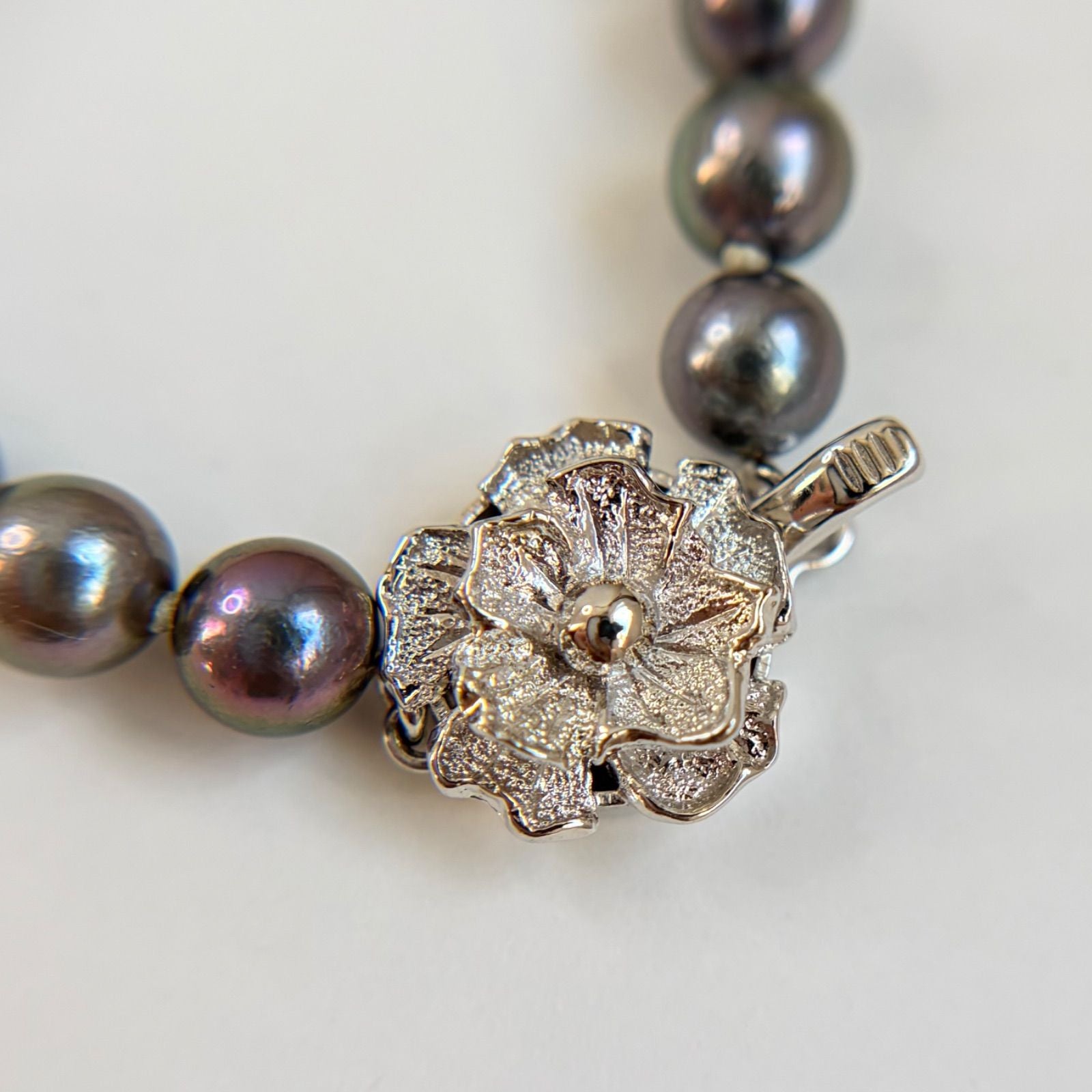 Silver necklace featuring a round black Akoya pearl 6.5-7mm with attached identification card on a 42cm chain