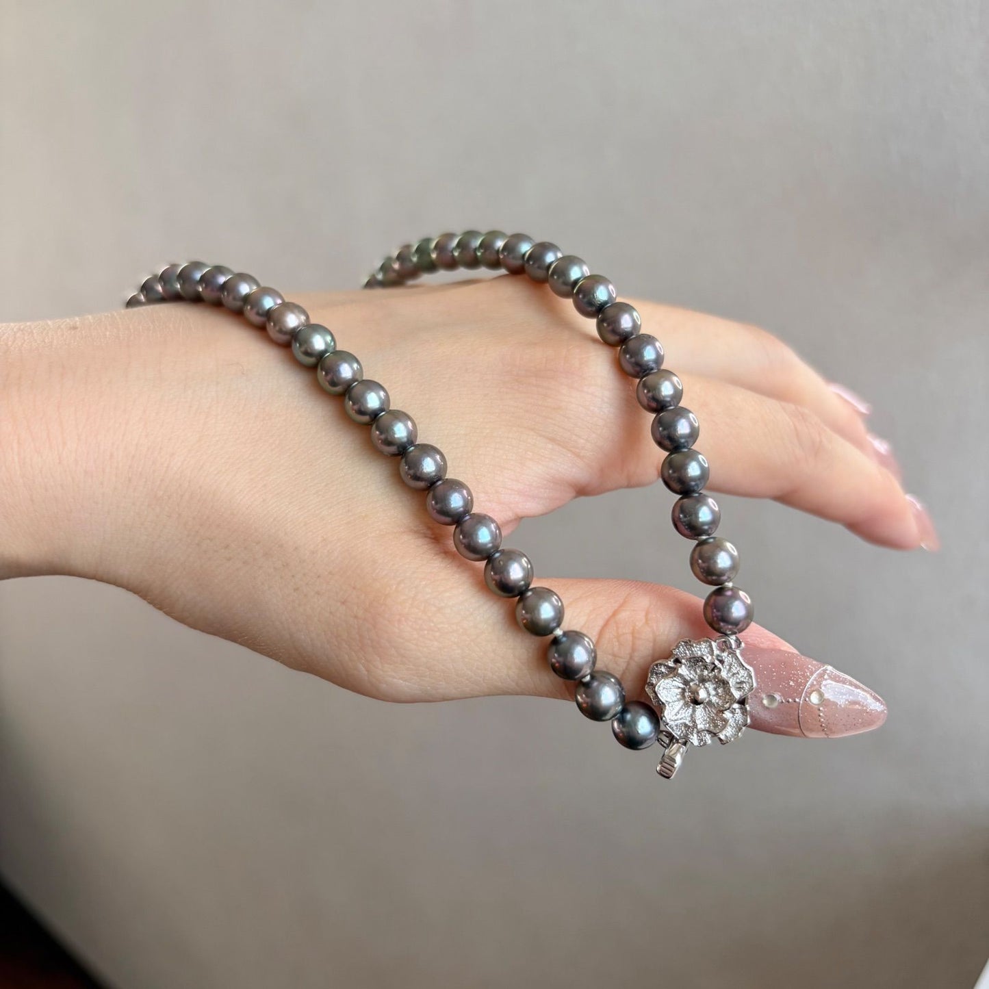 Silver necklace featuring a round black Akoya pearl 6.5-7mm with attached identification card on a 42cm chain