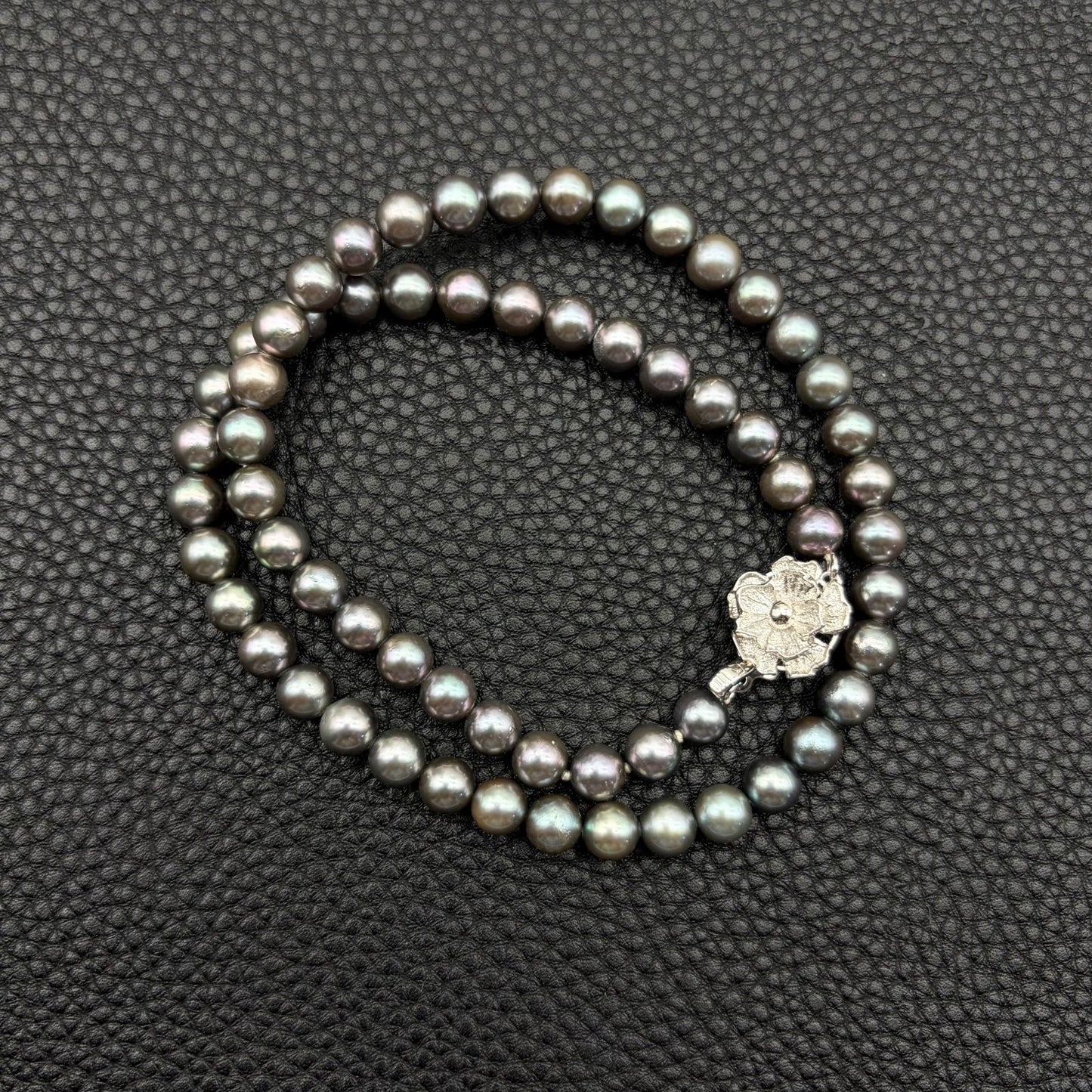 Silver necklace featuring a round black Akoya pearl 6.5-7mm with attached identification card on a 42cm chain