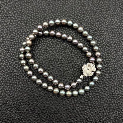Silver necklace featuring a round black Akoya pearl 6.5-7mm with attached identification card on a 42cm chain