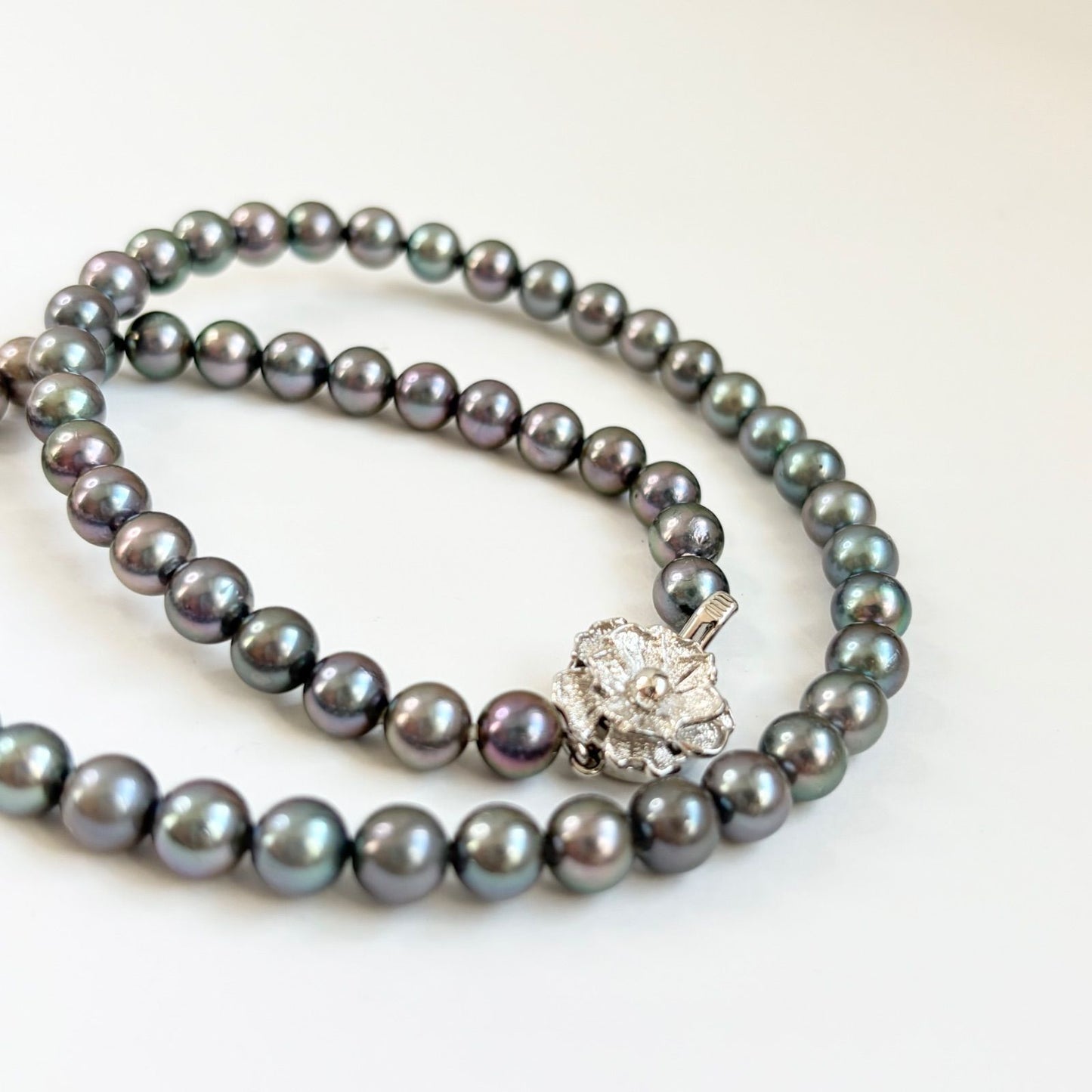 Silver necklace featuring a round black Akoya pearl 6.5-7mm with attached identification card on a 42cm chain