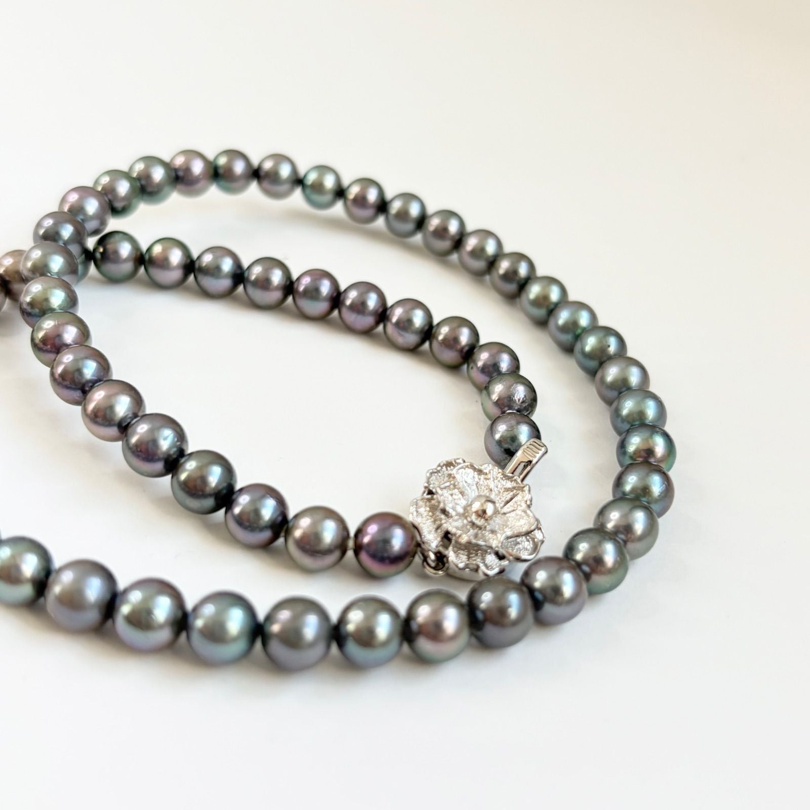 Silver necklace featuring a round black Akoya pearl 6.5-7mm with attached identification card on a 42cm chain