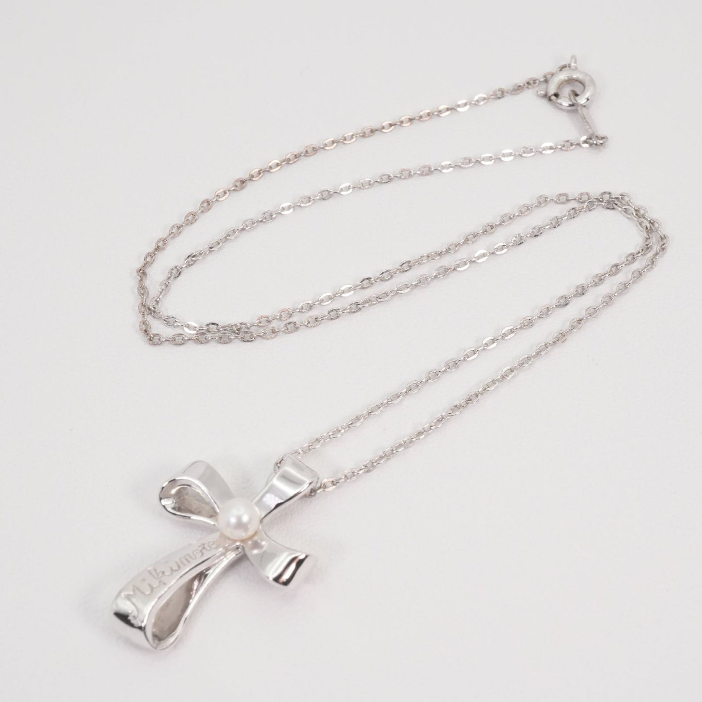 Mikimoto silver necklace with a baby pearl cross pendant, showcasing delicate craftsmanship and polished finish