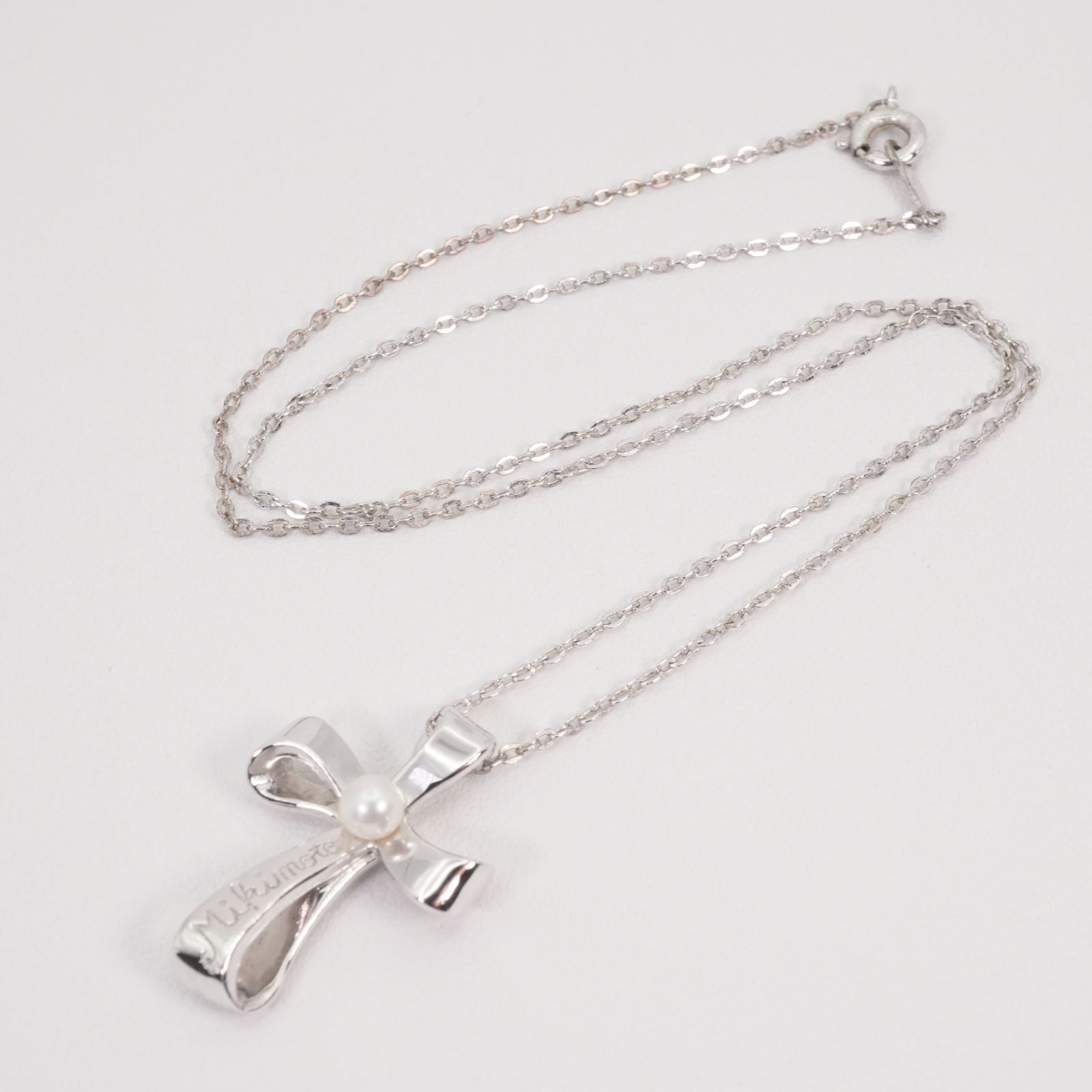 Mikimoto silver necklace with a baby pearl cross pendant, showcasing delicate craftsmanship and polished finish