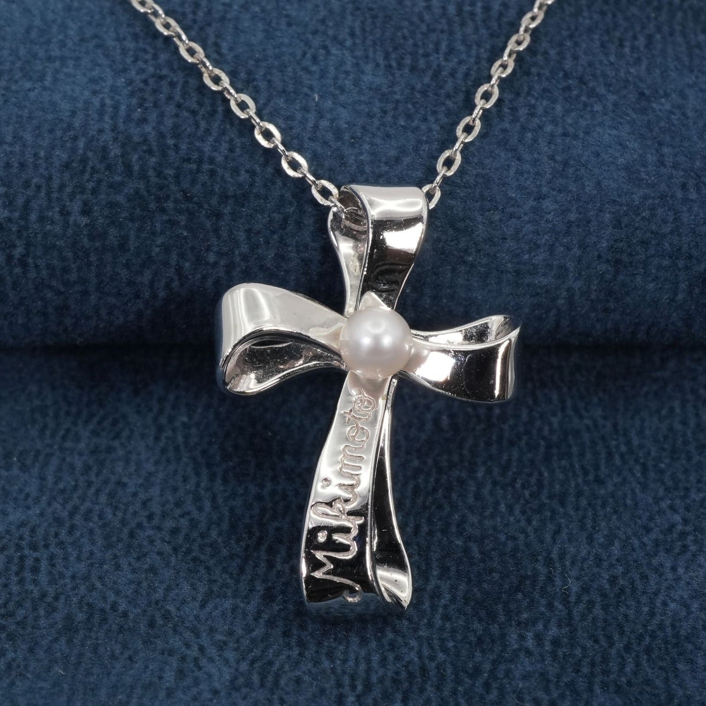 Mikimoto silver necklace with a baby pearl cross pendant, showcasing delicate craftsmanship and polished finish