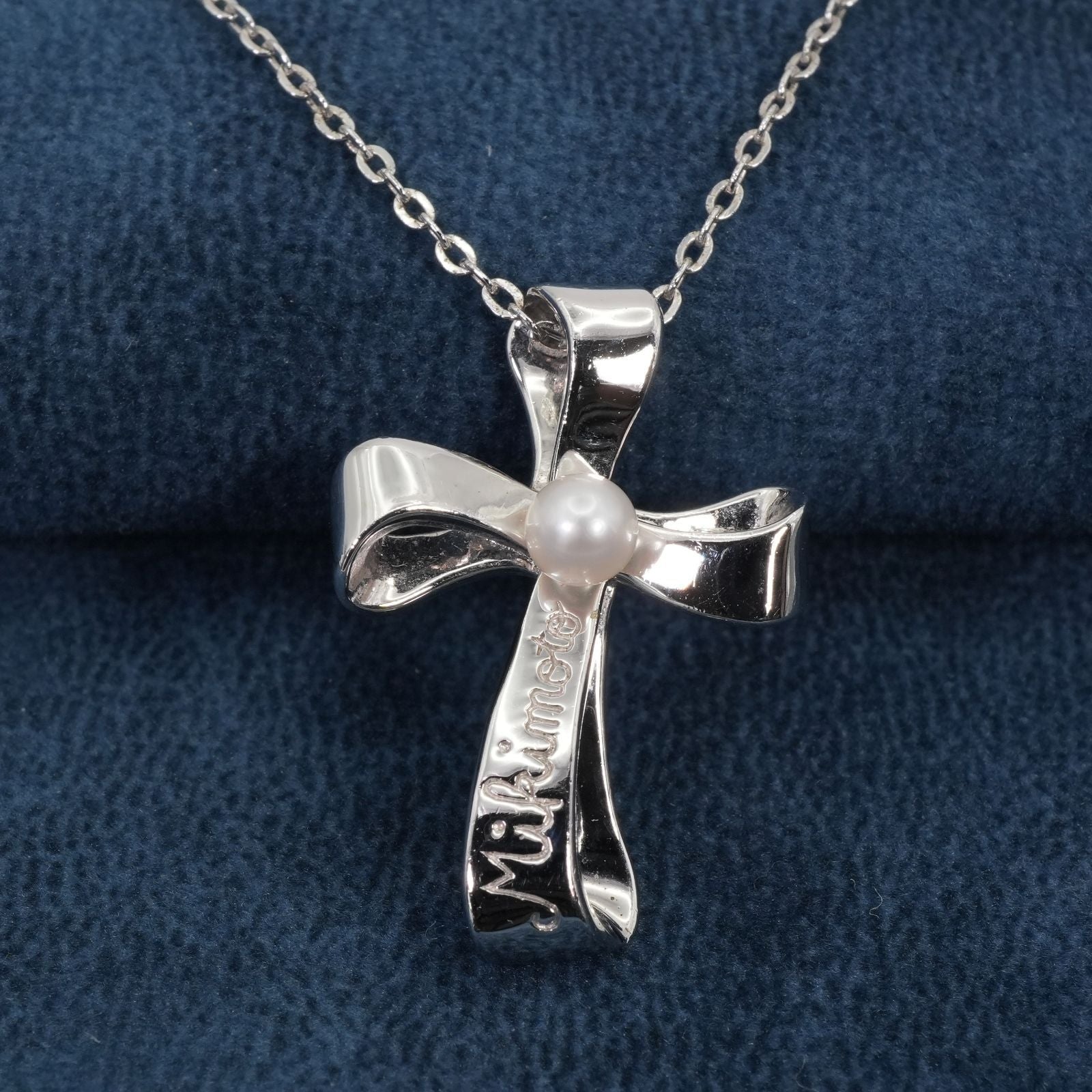 Mikimoto silver necklace with a baby pearl cross pendant, showcasing delicate craftsmanship and polished finish