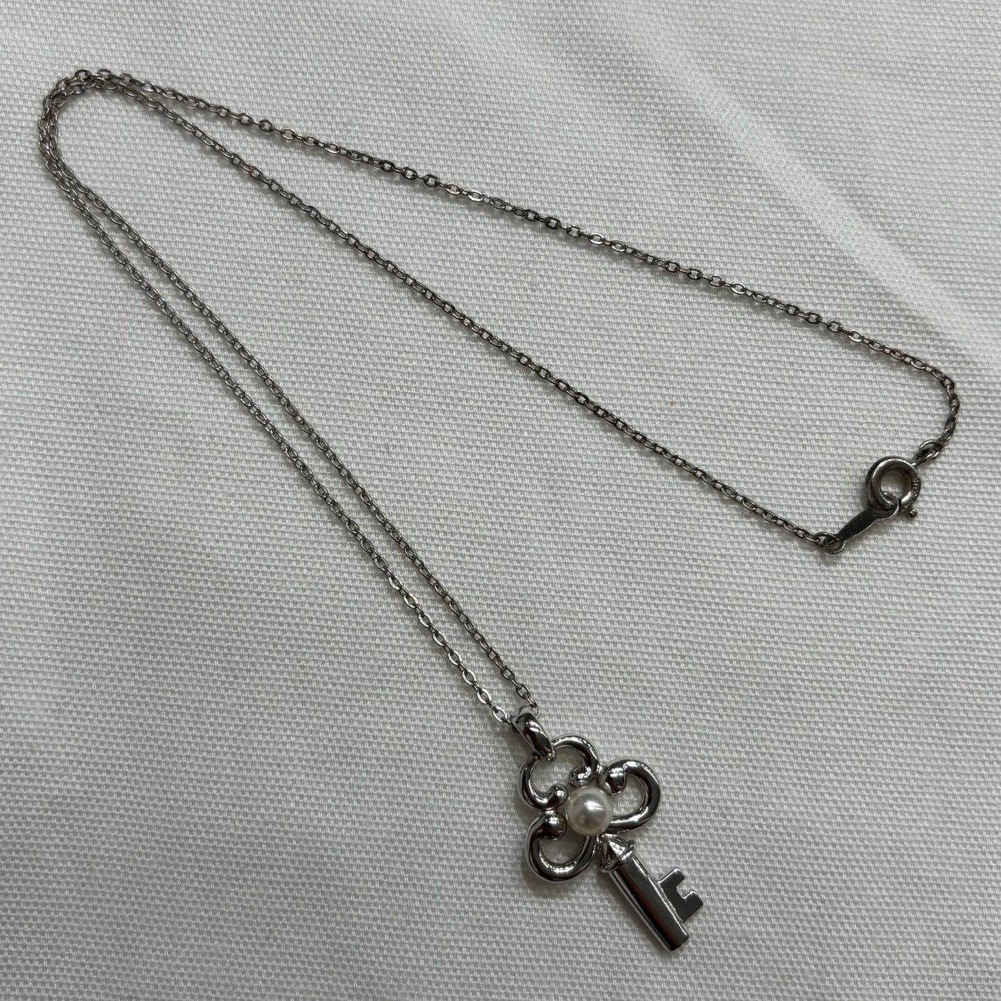 MIKIMOTO silver necklace with key-shaped pendant featuring a central pearl on a 40 cm chain