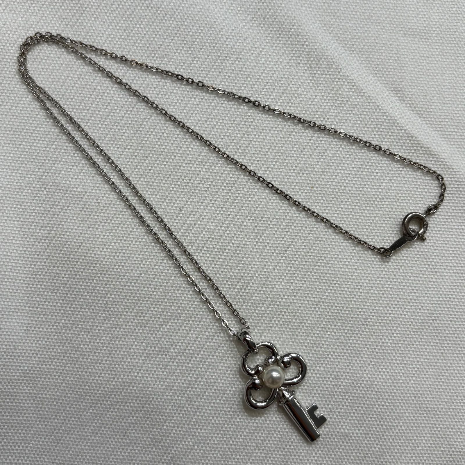 MIKIMOTO silver necklace with key-shaped pendant featuring a central pearl on a 40 cm chain