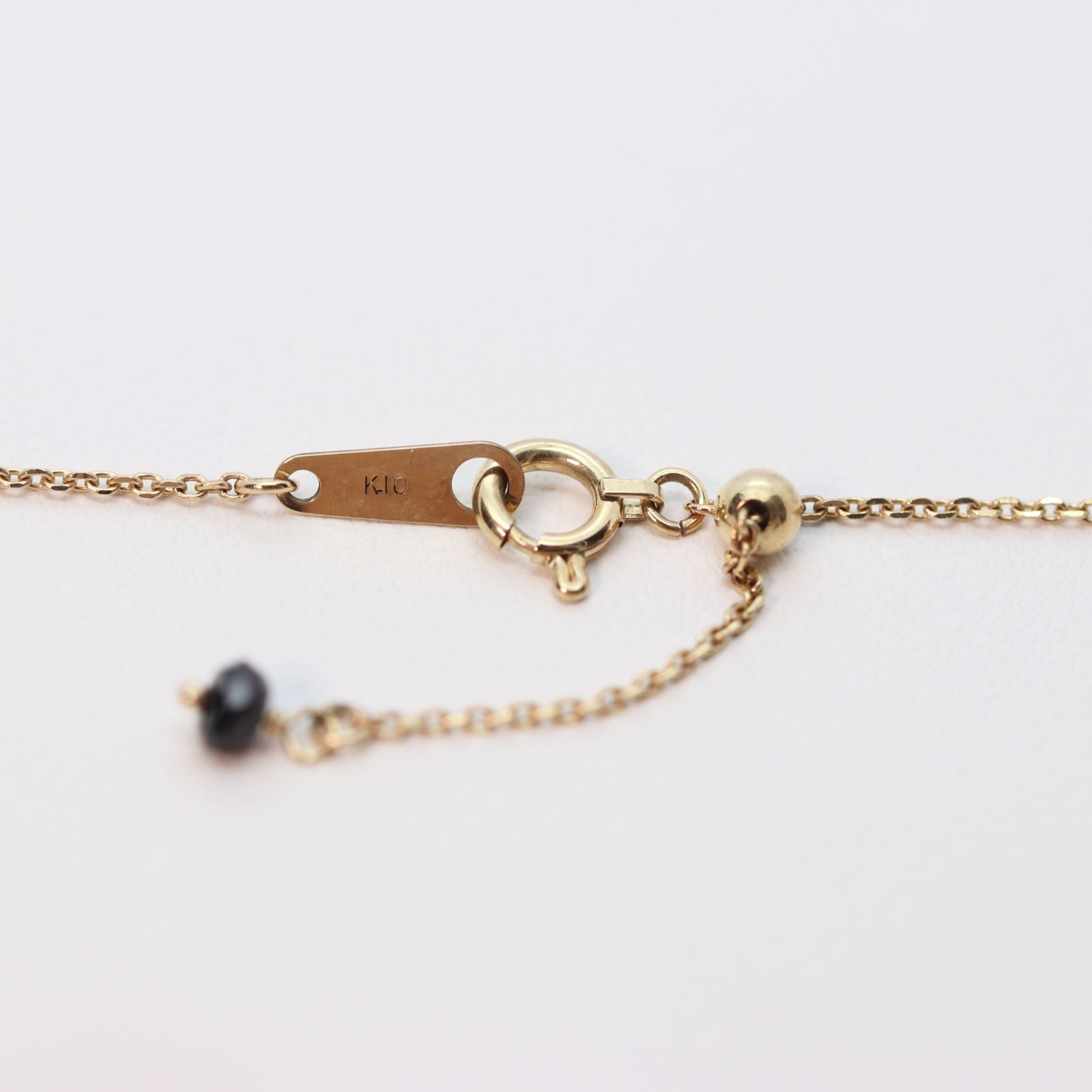 Agete K10 gold necklace with black onyx and slide adjuster on a white background