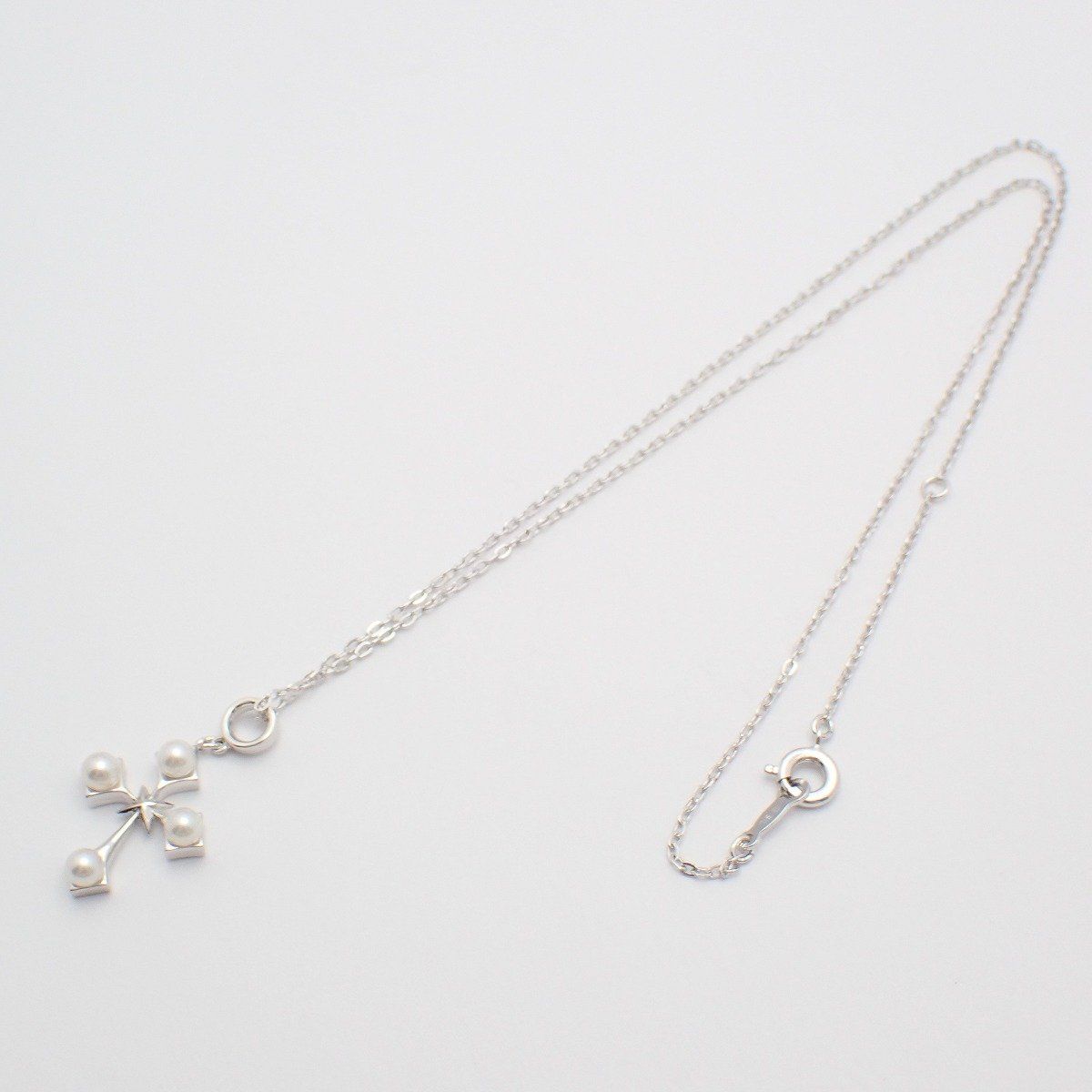 Mikimoto silver cross necklace featuring four small pearls and adjustable chain
