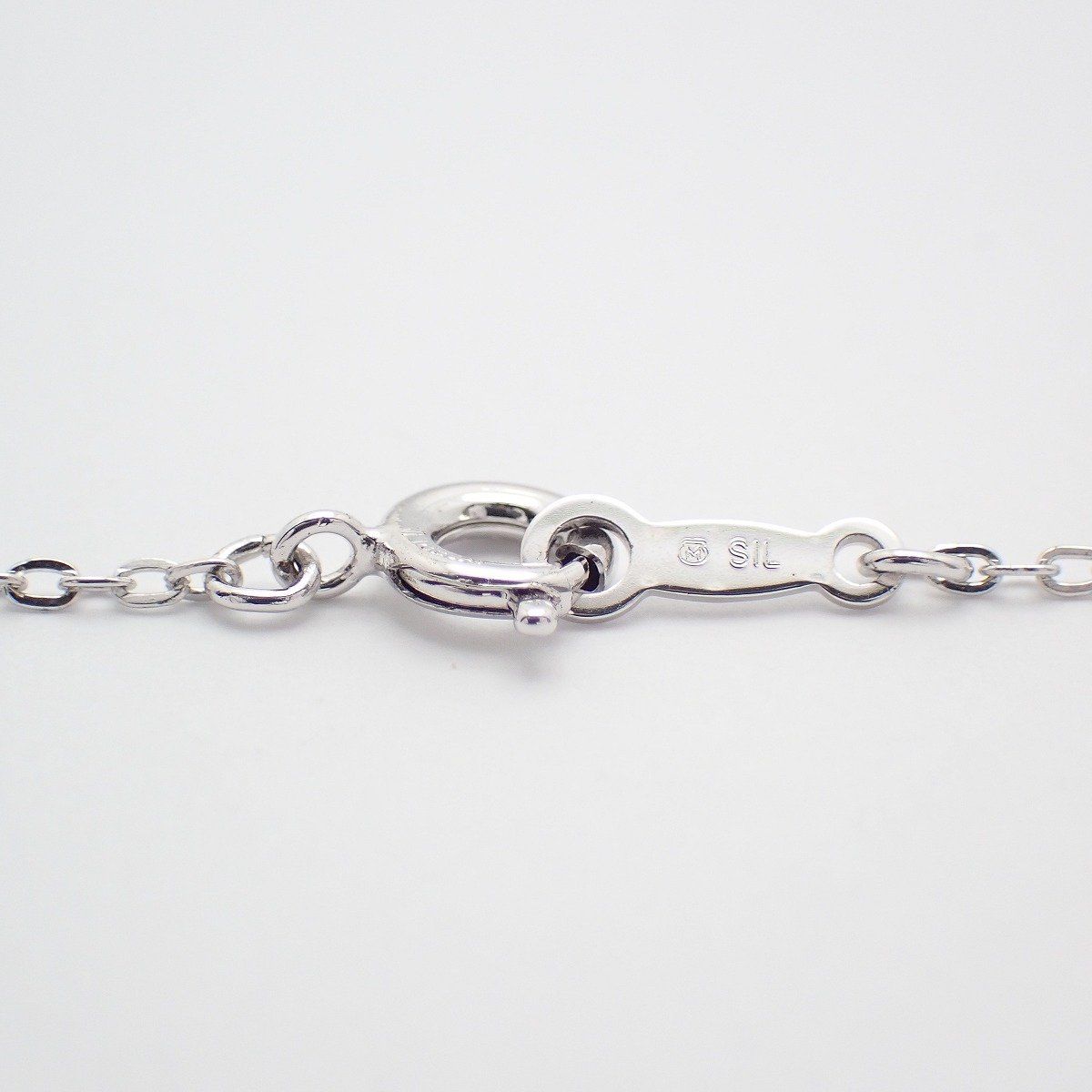 Mikimoto silver cross necklace featuring four small pearls and adjustable chain