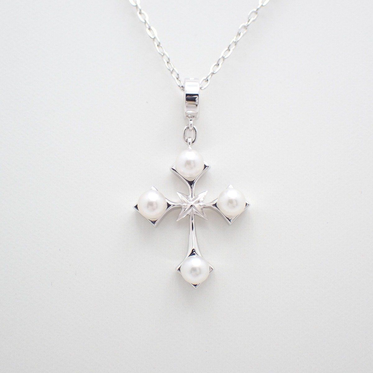 Mikimoto silver cross necklace featuring four small pearls and adjustable chain