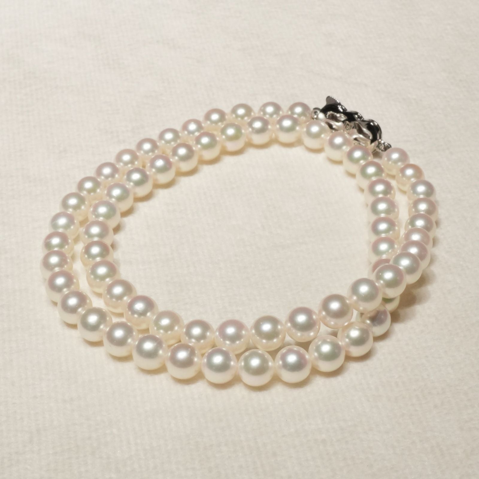 Mikimoto Akoya pearl necklace with 6.4mm pearls and silver current clasp on white background