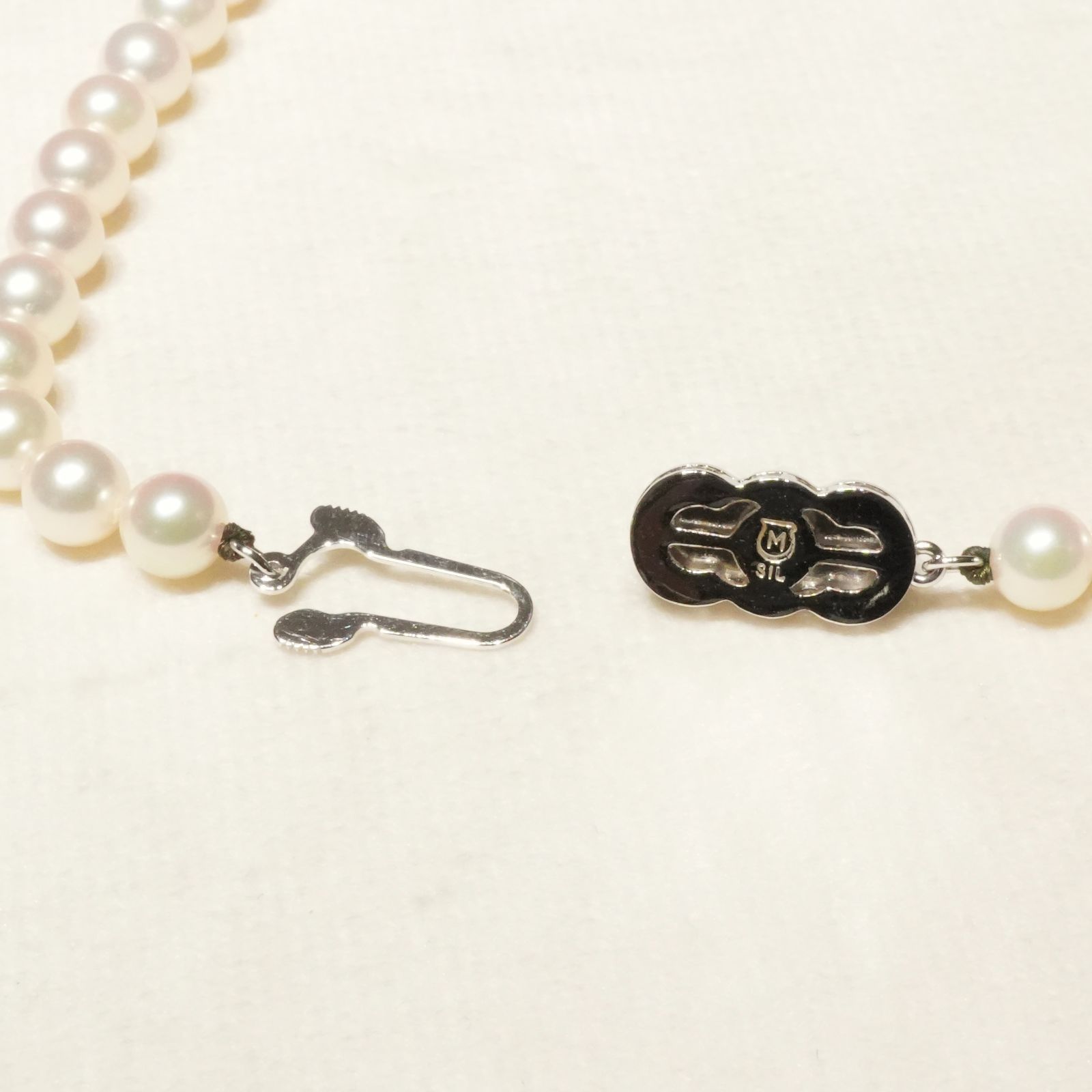 Mikimoto Akoya pearl necklace with 6.4mm pearls and silver current clasp on white background