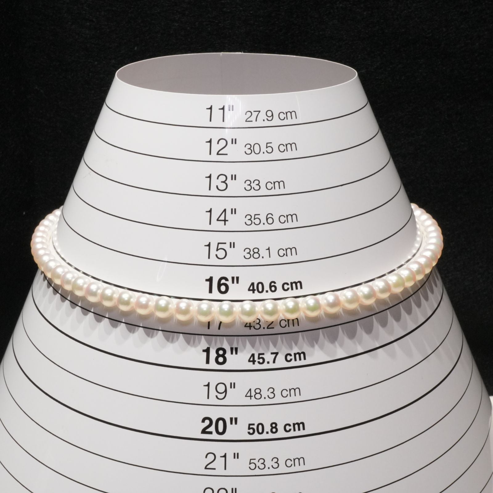 Mikimoto Akoya pearl necklace with 6.4mm pearls and silver current clasp on white background