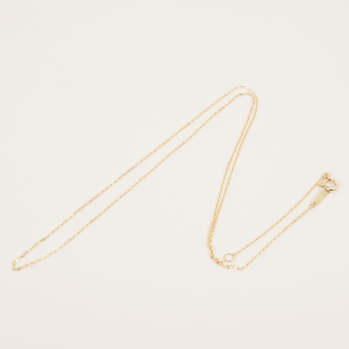 Agete K10 gold necklace chain laid out showing its fine links and polished finish