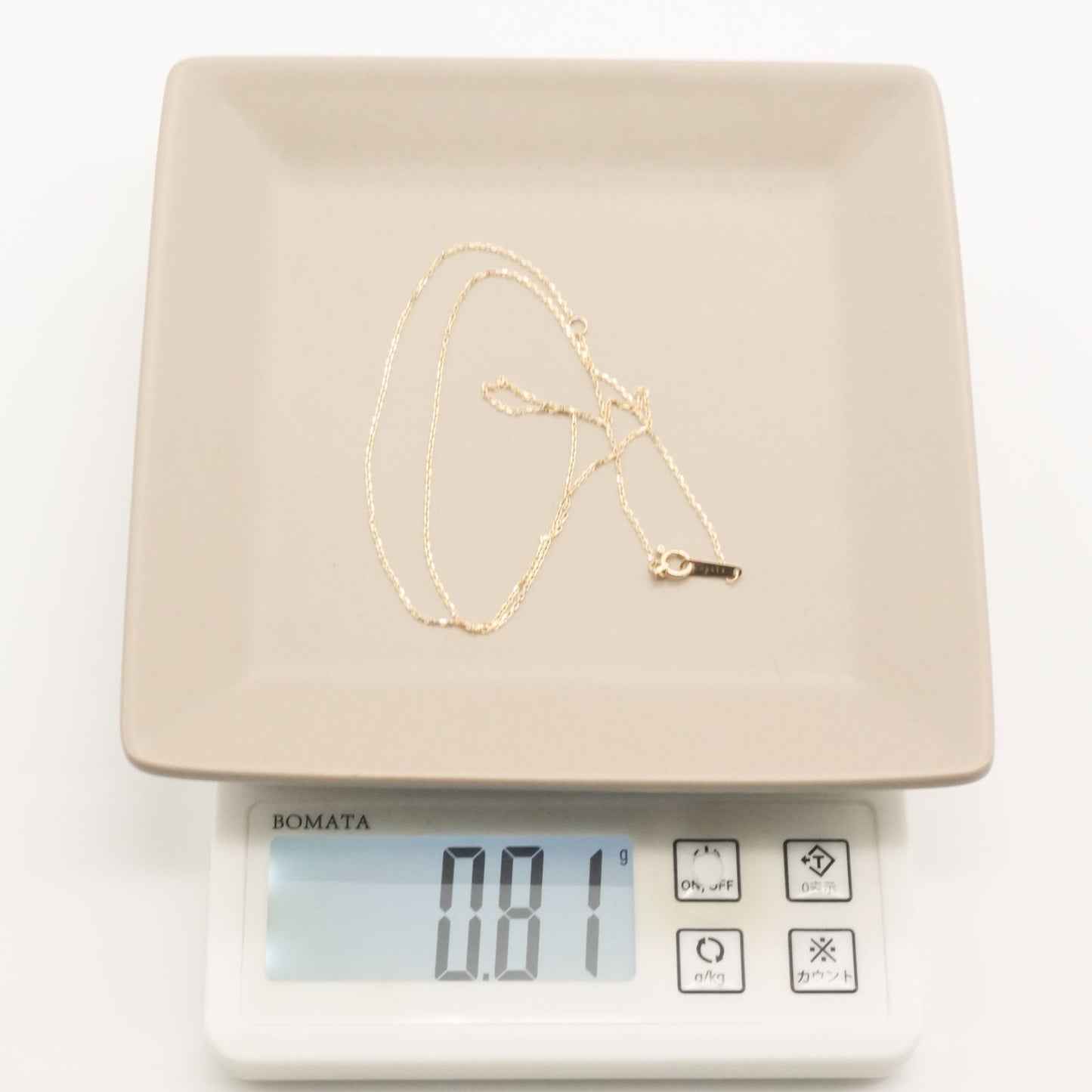 Agete K10 gold necklace chain laid out showing its fine links and polished finish