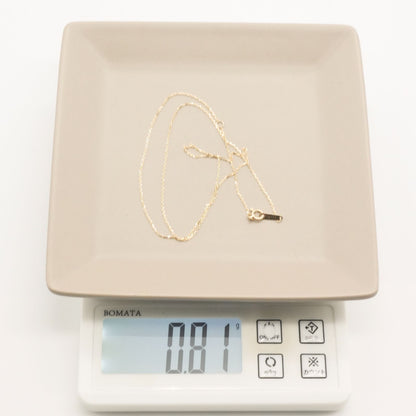 Agete K10 gold necklace chain laid out showing its fine links and polished finish