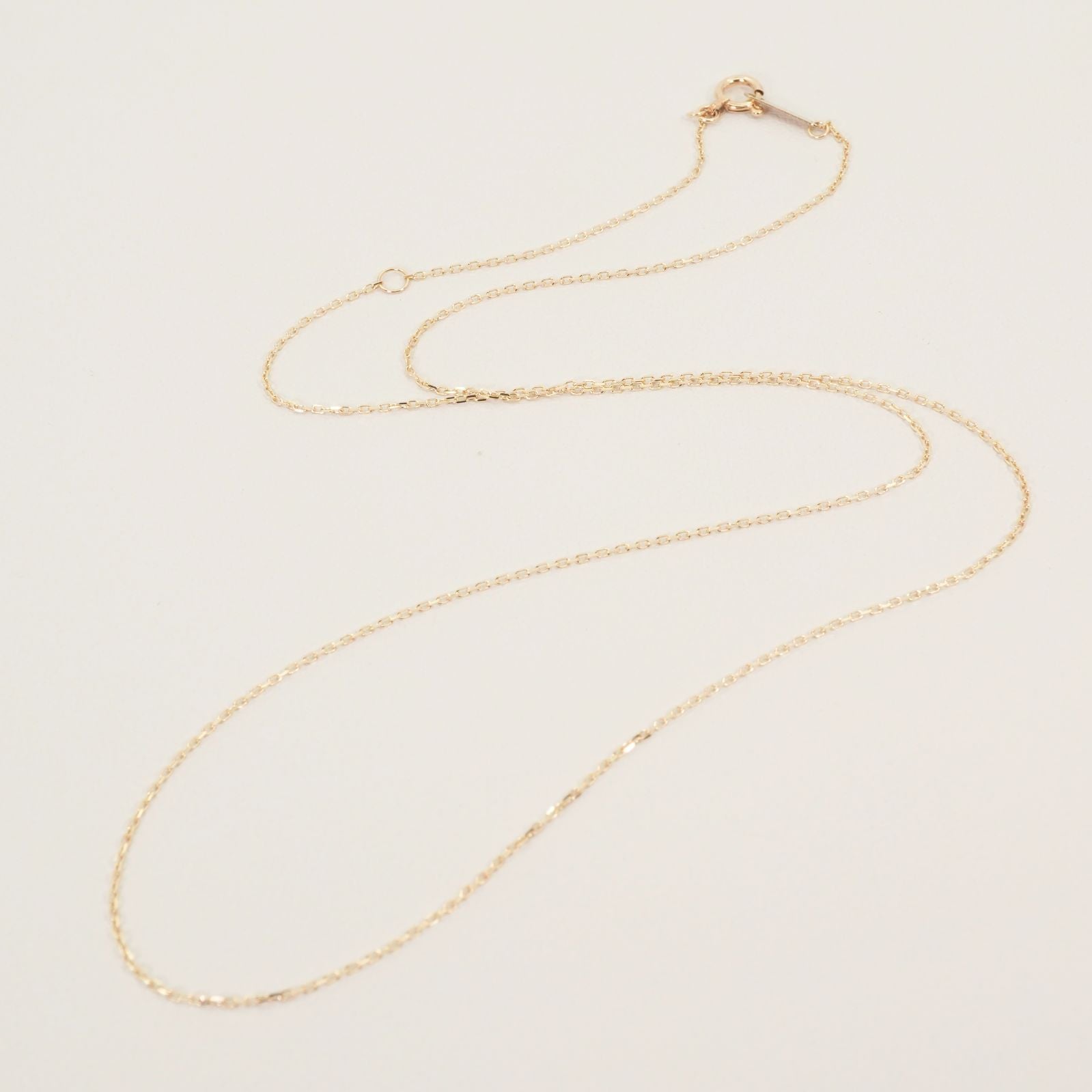 Agete K10 gold necklace chain laid out showing its fine links and polished finish