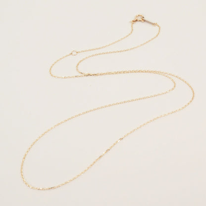 Agete K10 gold necklace chain laid out showing its fine links and polished finish