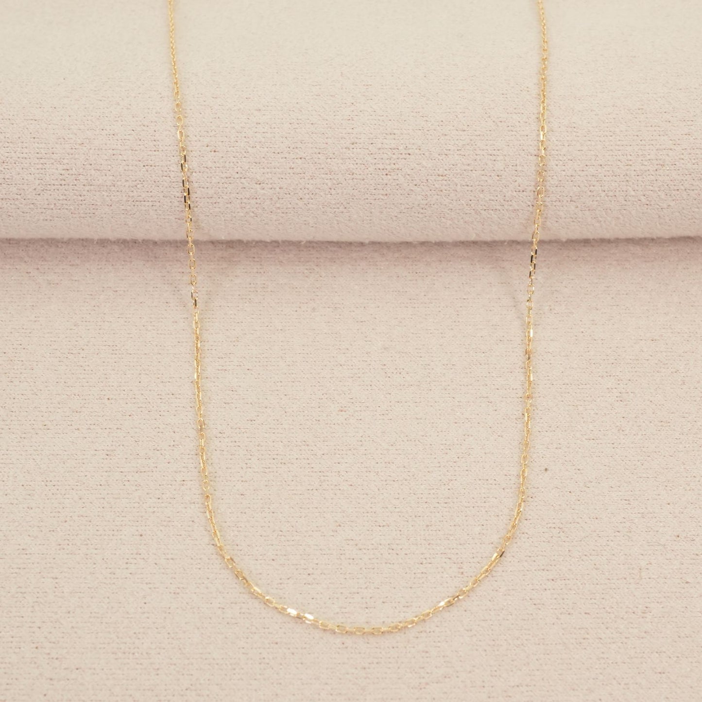 Agete K10 gold necklace chain laid out showing its fine links and polished finish