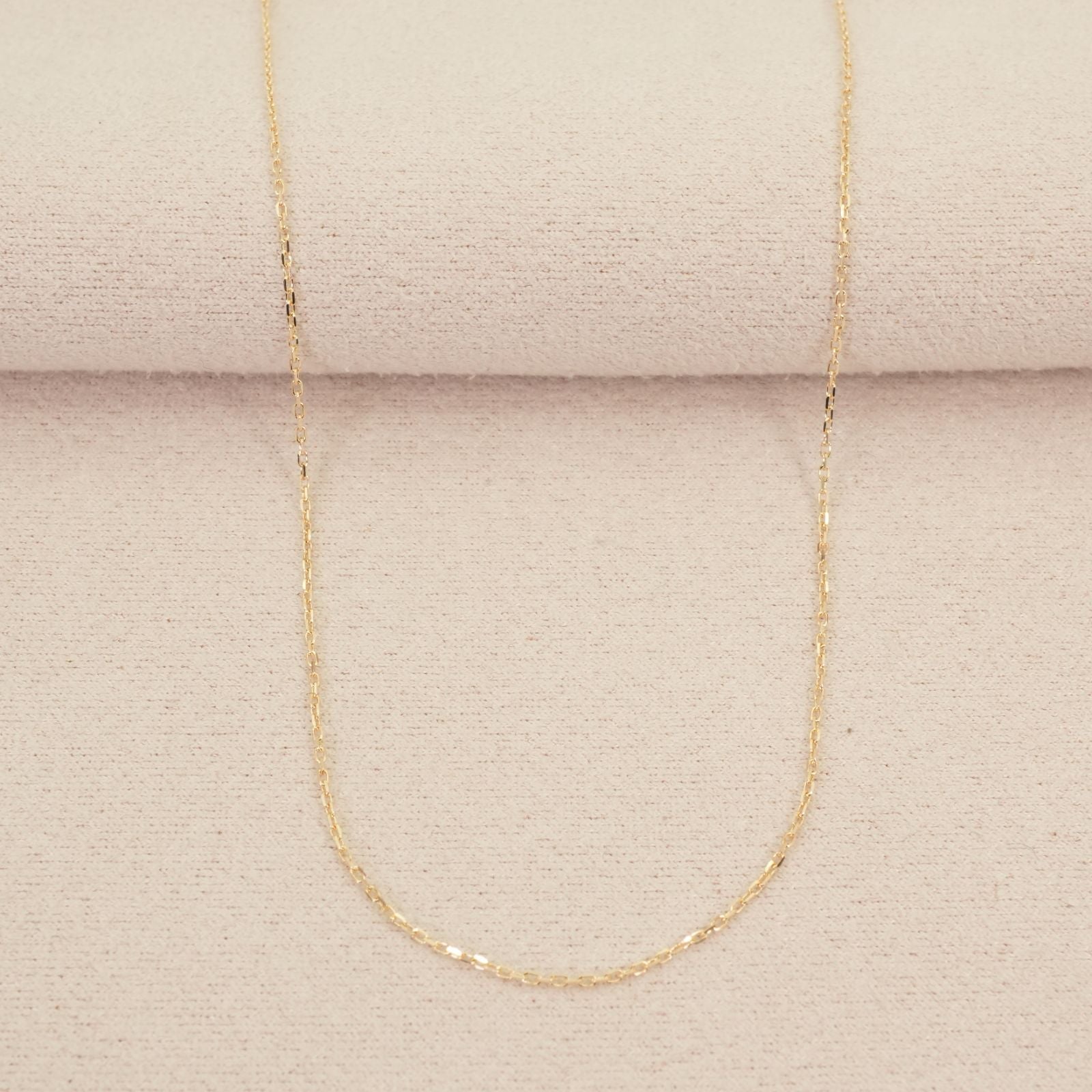 Agete K10 gold necklace chain laid out showing its fine links and polished finish