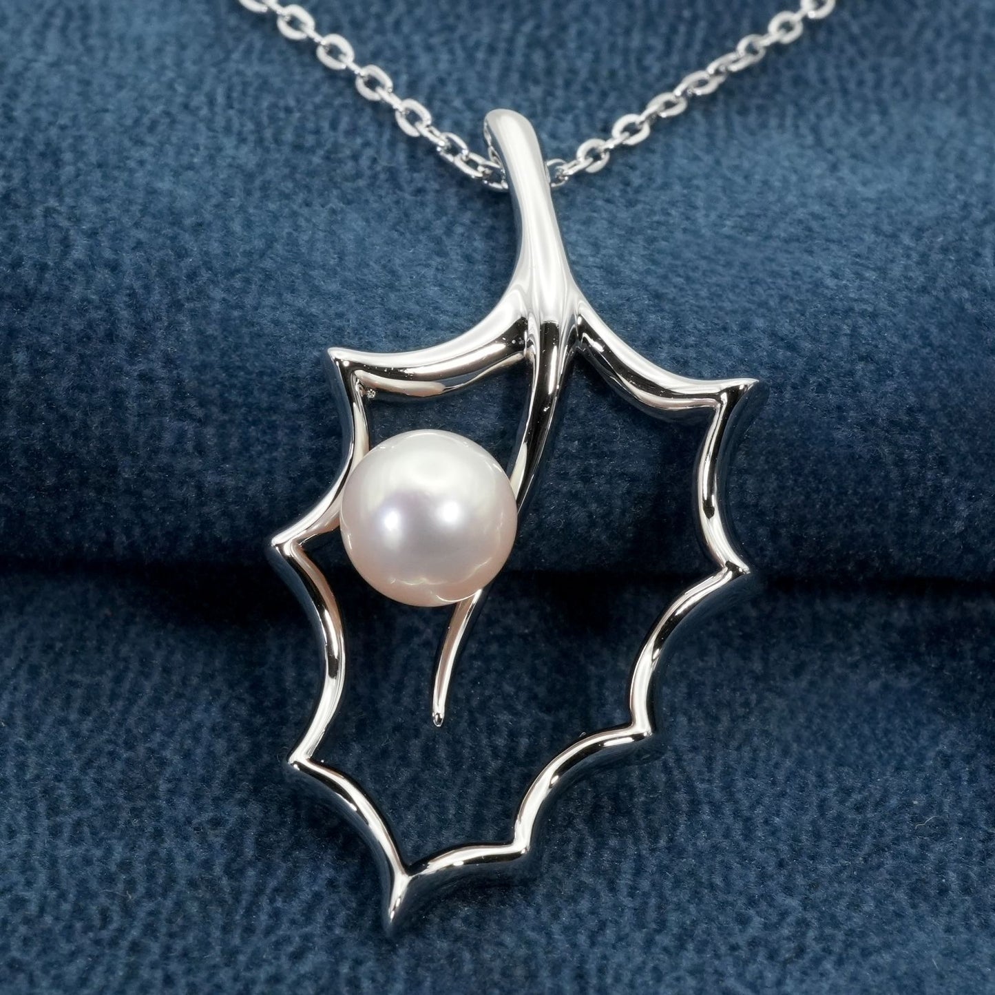 Mikimoto Hollyhock necklace featuring a silver chain and a single pearl pendant with floral design