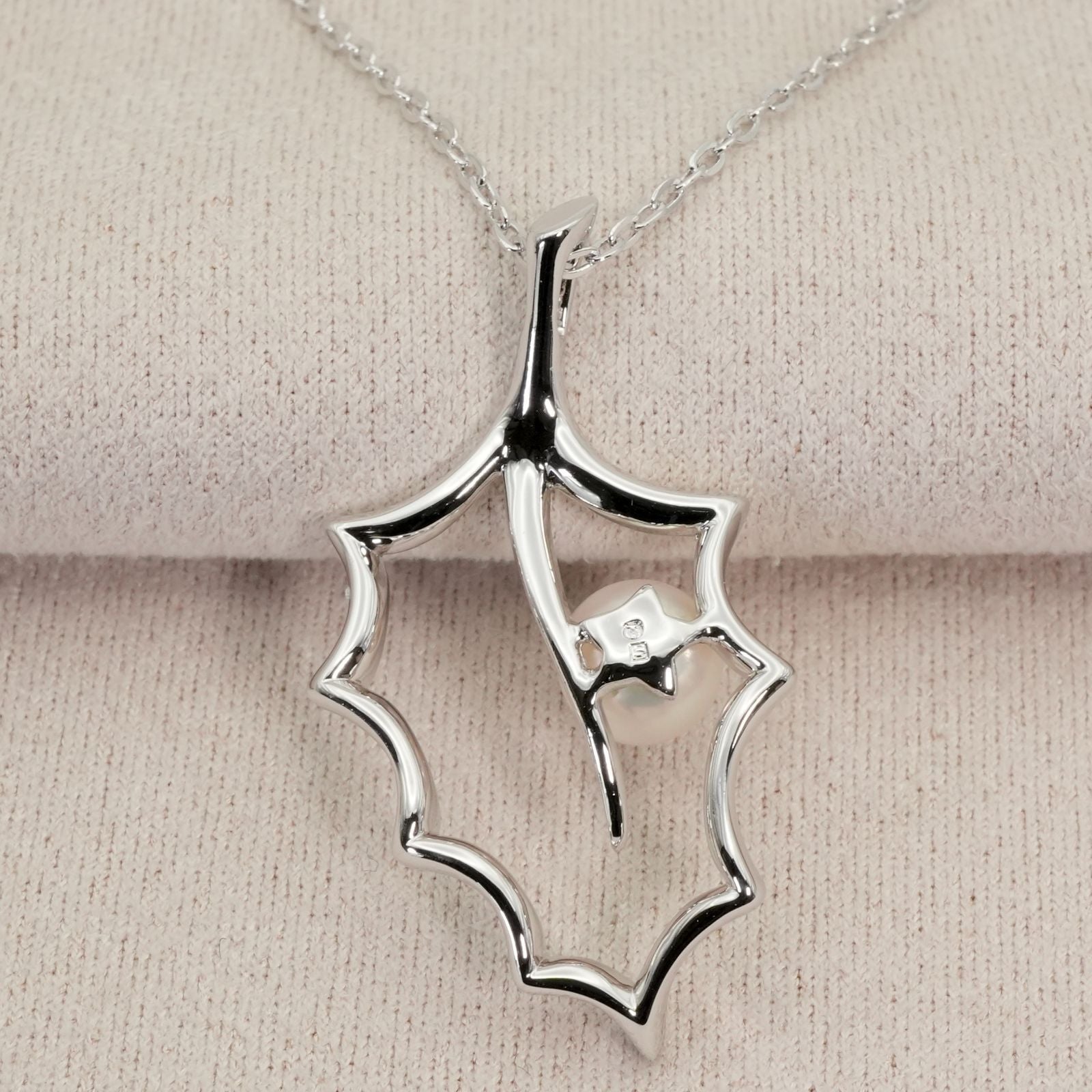 Mikimoto Hollyhock necklace featuring a silver chain and a single pearl pendant with floral design