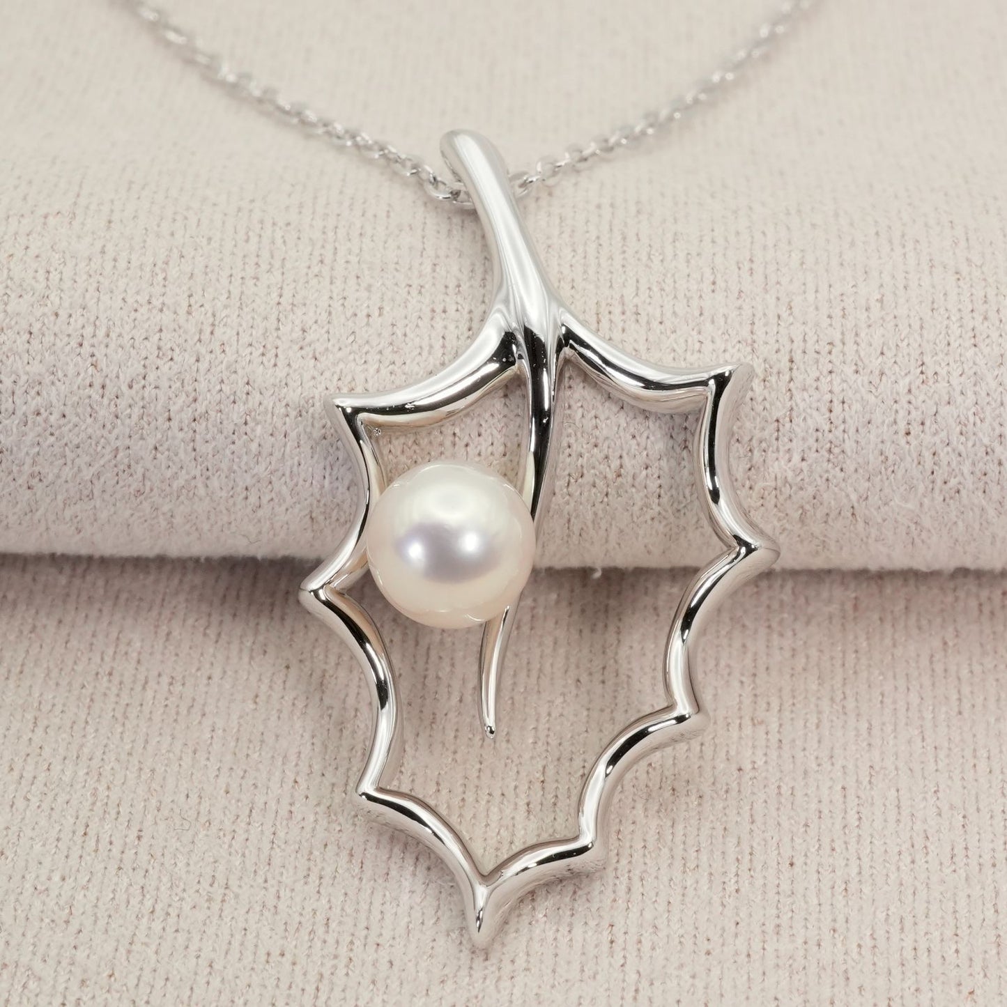 Mikimoto Hollyhock necklace featuring a silver chain and a single pearl pendant with floral design