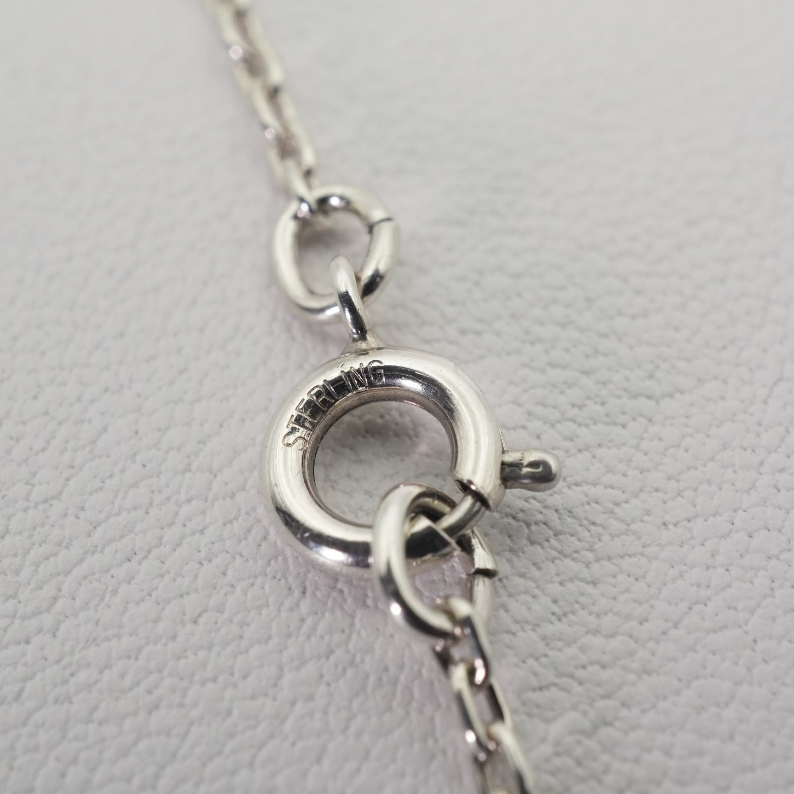 Agete silver necklace with a round shell cross charm on a delicate chain