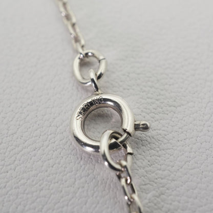 Agete silver necklace with a round shell cross charm on a delicate chain