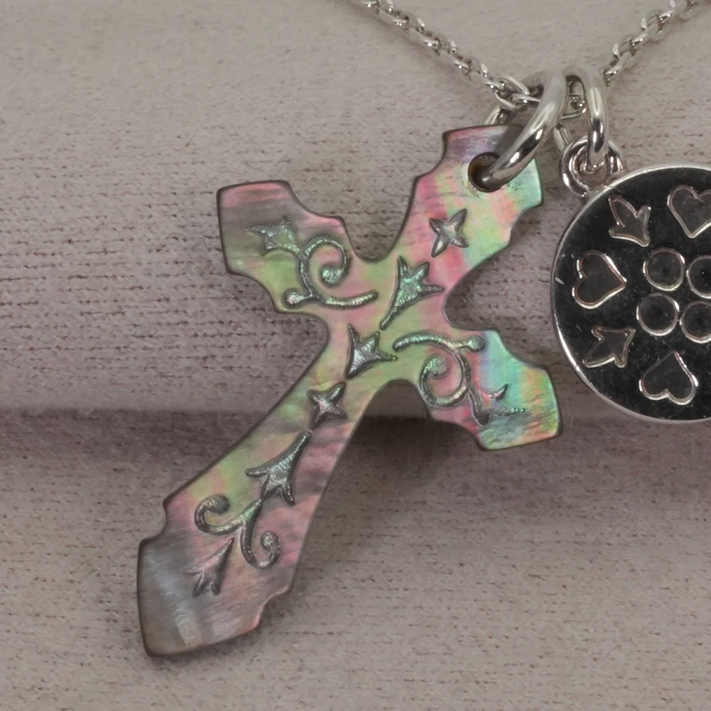 Agete silver necklace with a round shell cross charm on a delicate chain