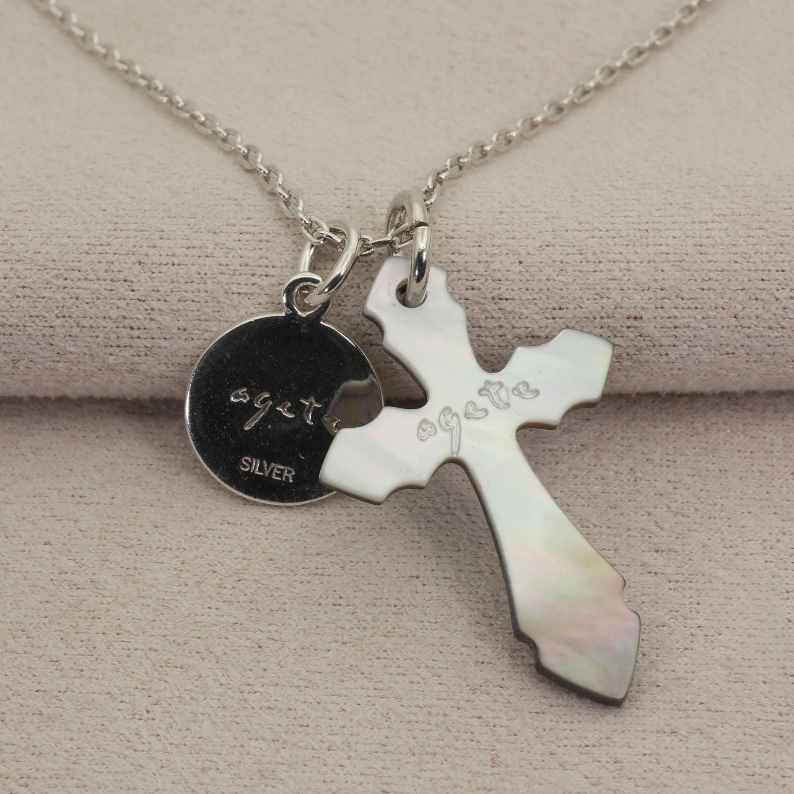 Agete silver necklace with a round shell cross charm on a delicate chain