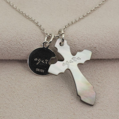 Agete silver necklace with a round shell cross charm on a delicate chain
