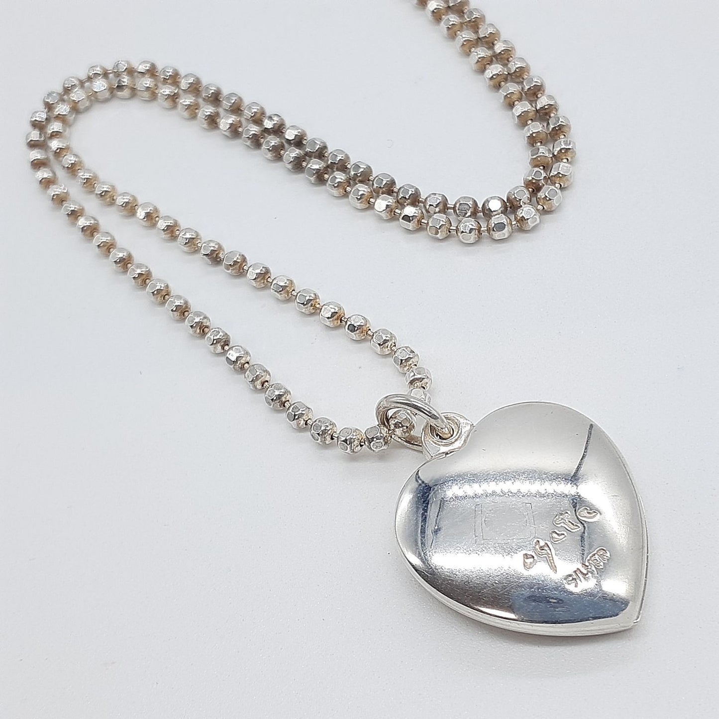 Agete heart-shaped silver necklace with heart rocket and clover charm on silver chain