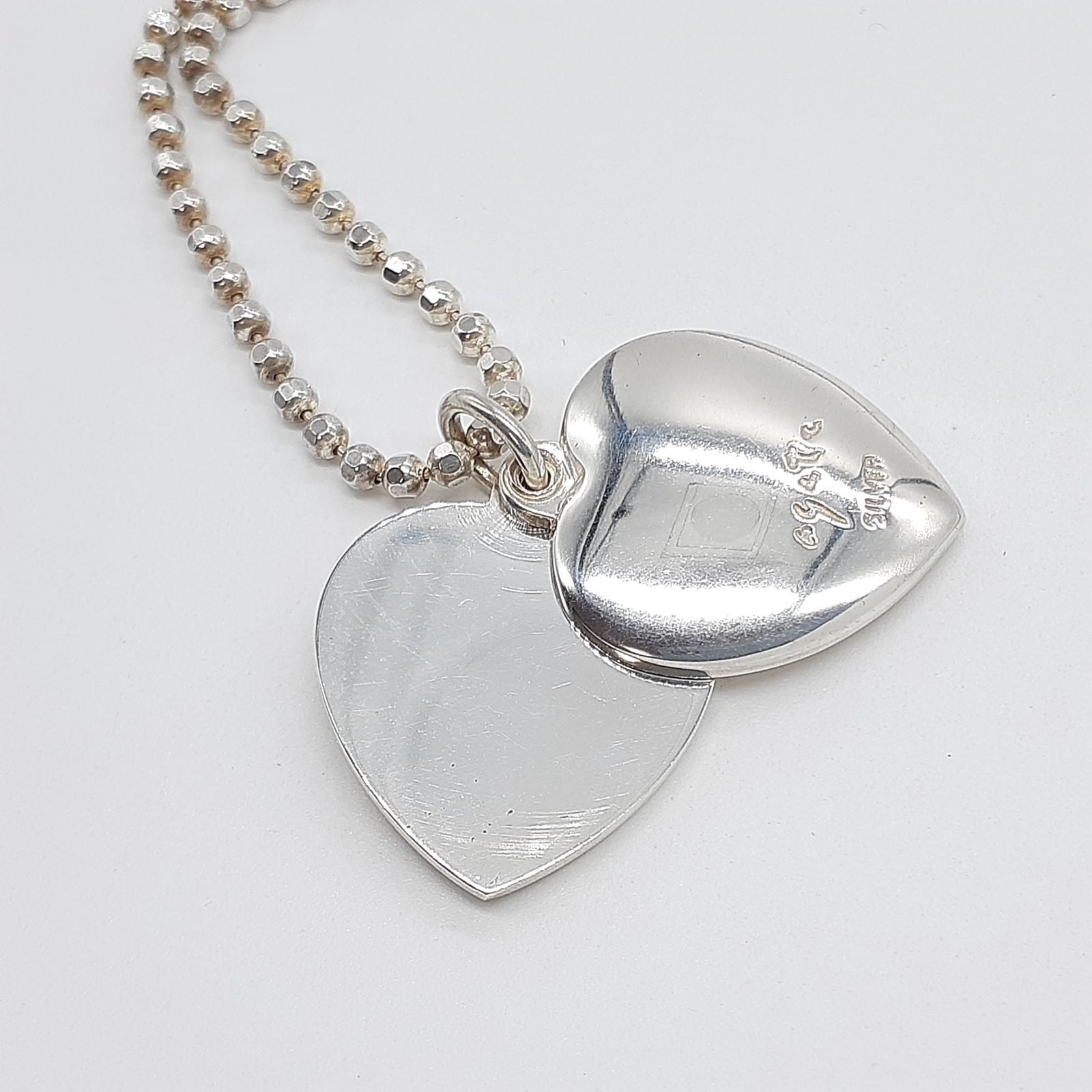 Agete heart-shaped silver necklace with heart rocket and clover charm on silver chain