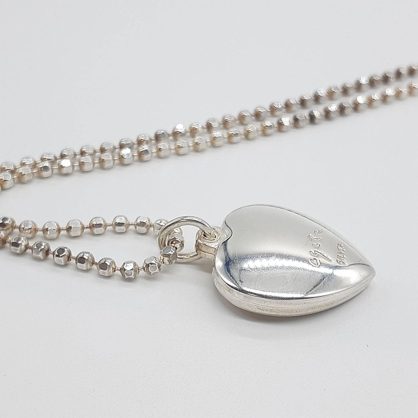 Agete heart-shaped silver necklace with heart rocket and clover charm on silver chain